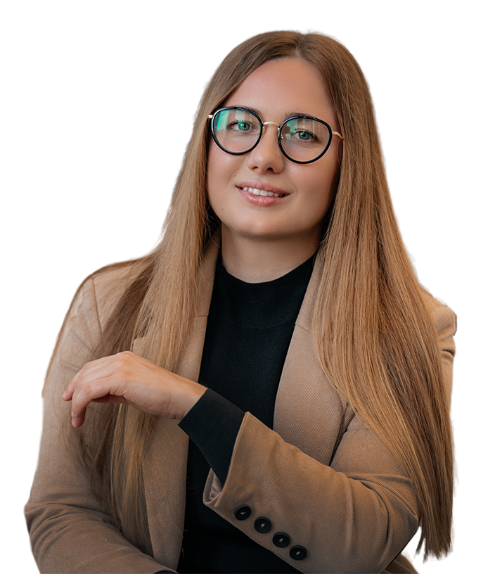 A woman with long hair wearing glasses and a beige blazer, sitting and smiling while resting her hand on her arm. The background is neutral, emphasizing her professional appearance, relevant to software development and ODG.